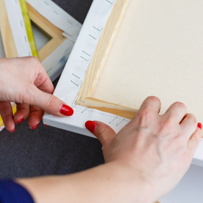 Person measuring a wooden frame with a ruler