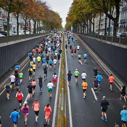 Runners participating in a marathon on a city street lined with trees and buildings.