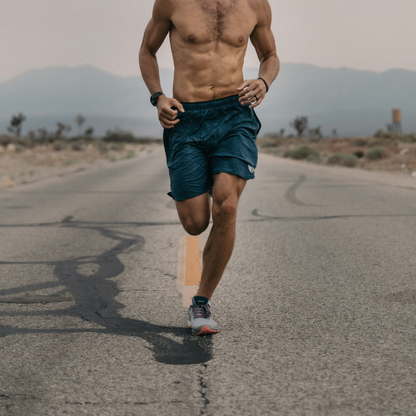 Man running on a deserted road with mountains in the background