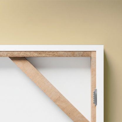 Wooden frame with white border on a beige wall