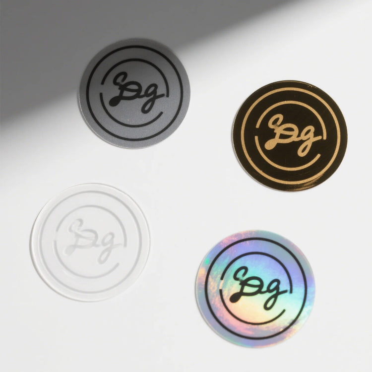 Four circular stickers with different designs and colors on a light gray background