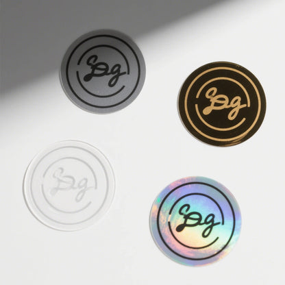 Four circular stickers with different designs and colors on a light gray background