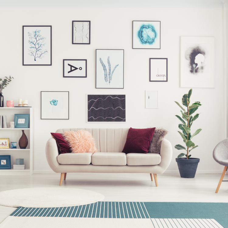Living room with a white sofa, decorative pillows, and framed artwork on the wall.