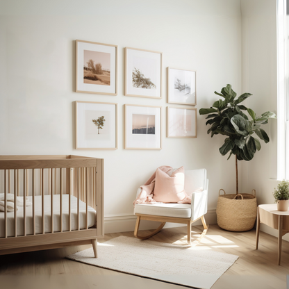 Nursery room with wooden crib, white chair, and framed pictures on the wall.